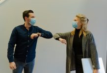 woman in black jacket holding white paper