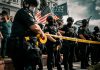 man in black shirt holding american flag
