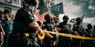 man in black shirt holding american flag