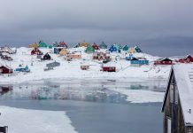 view photography of assorted-color houses near pond during daytime