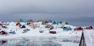 view photography of assorted-color houses near pond during daytime