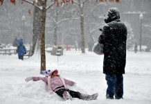 A little girl makes a snow angel
