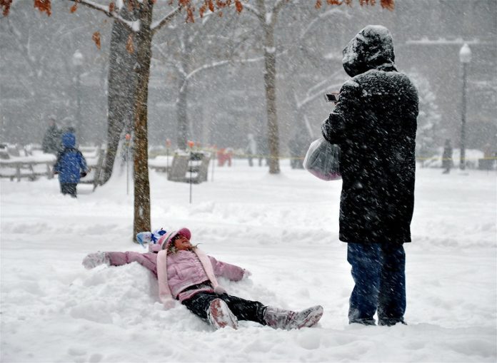 A little girl makes a snow angel